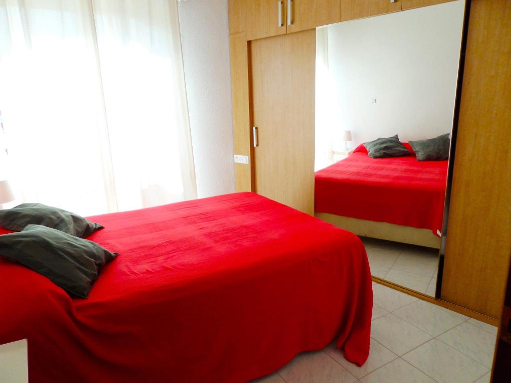 1 dormitorio con 2 camas rojas y espejo en Dream Apto Old Town, en Málaga