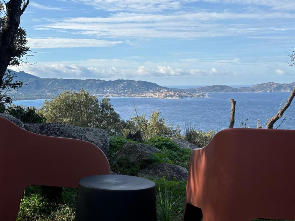 a view of the ocean with two chairs at CAMPING MONTE ORTU in Lumio
