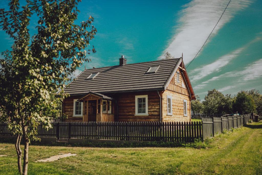a small wooden house with a black roof at Na wsi Zalesie 53 in Wyszki