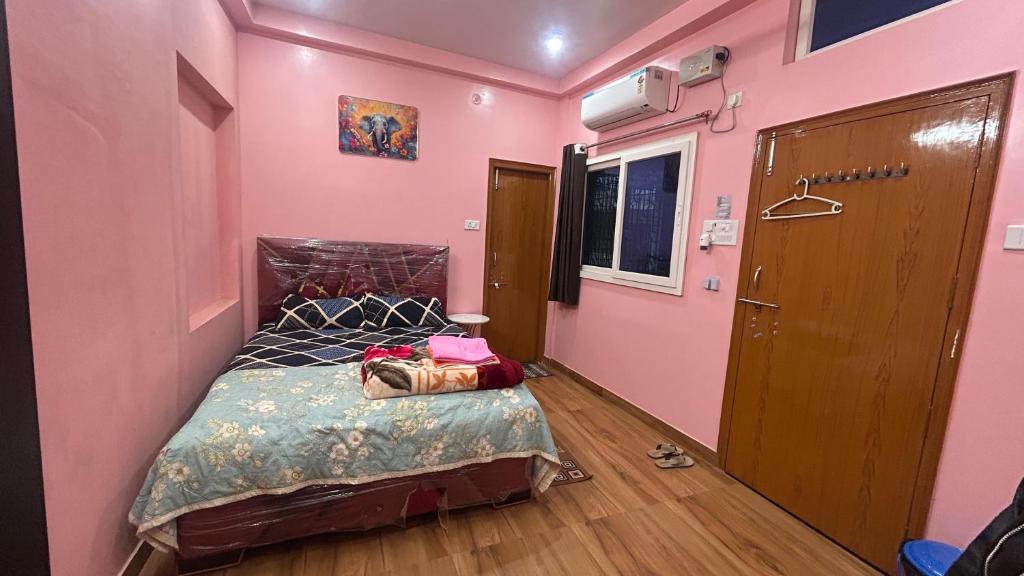 a bedroom with a bed in a pink room at Residency Trilok in Varanasi