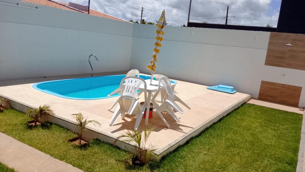 a swimming pool with two lawn chairs and a swing at Casa temporada aracaju sergipe in Aracaju