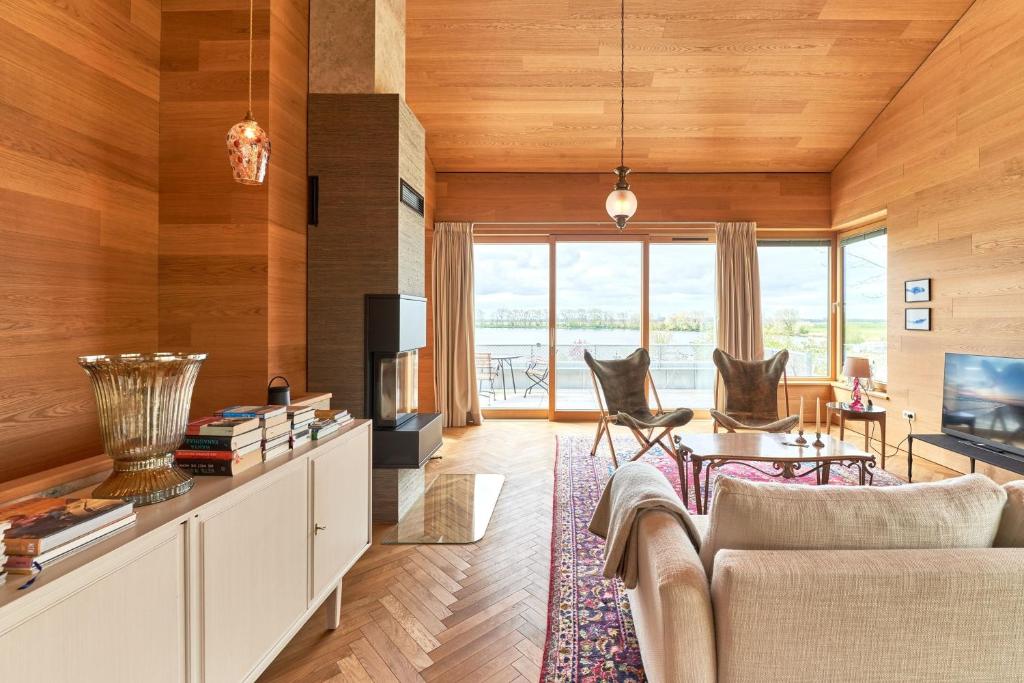 a living room with a couch and a table with chairs at IDAHO - Hoog in Süderstapel
