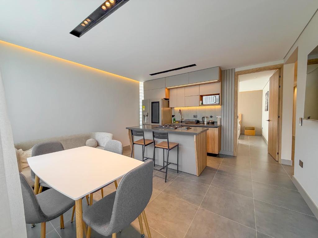 een keuken en woonkamer met een tafel en stoelen bij Apartamento de lujo a 3 minutos del Aeropuerto JMC 101 in Rionegro