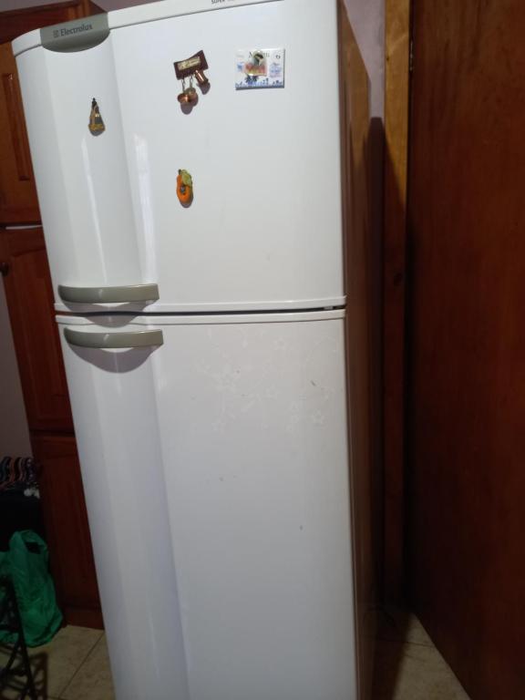 a white refrigerator in a kitchen with magnets on it at kit net Rua Ildo Meneghetti, 160 in Alegrete