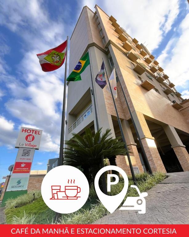 a building with two flags in front of it at Le Village Flats e Hotel in Joinville