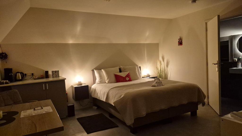 a bedroom with a large bed with two lamps at Dalerheugte Drenthe B&B Comfort 5 met eigen badkamer en ontbijt à la carte op de kamer in Dalerveen