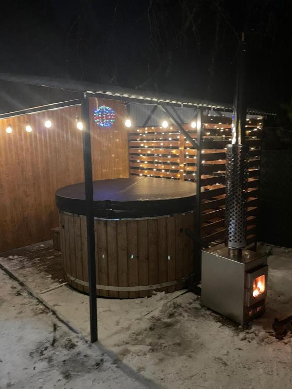 a sauna with a hot tub in the snow at night at Slow Orzechów in Sosnowica