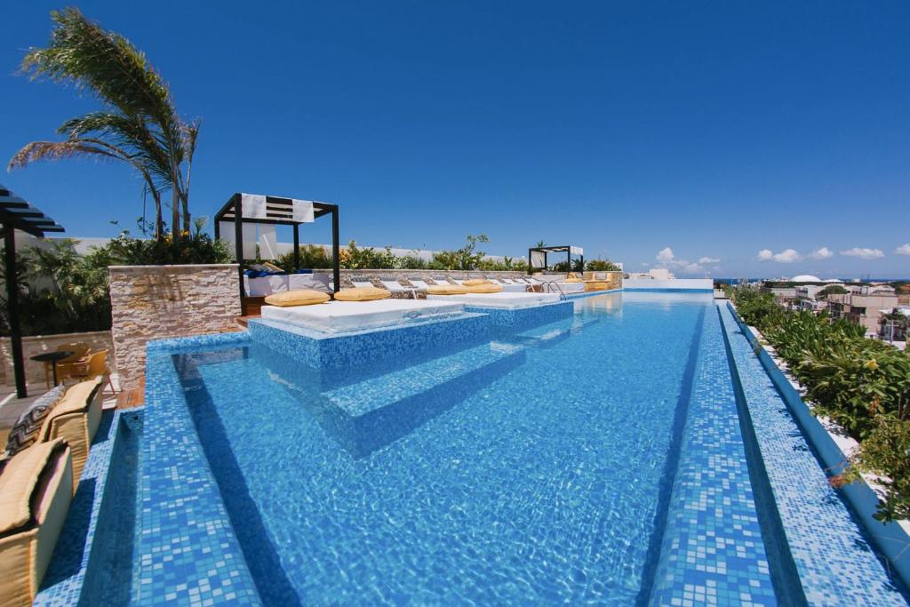 a swimming pool with a view of the ocean at The City Condos by Menesse in Playa del Carmen