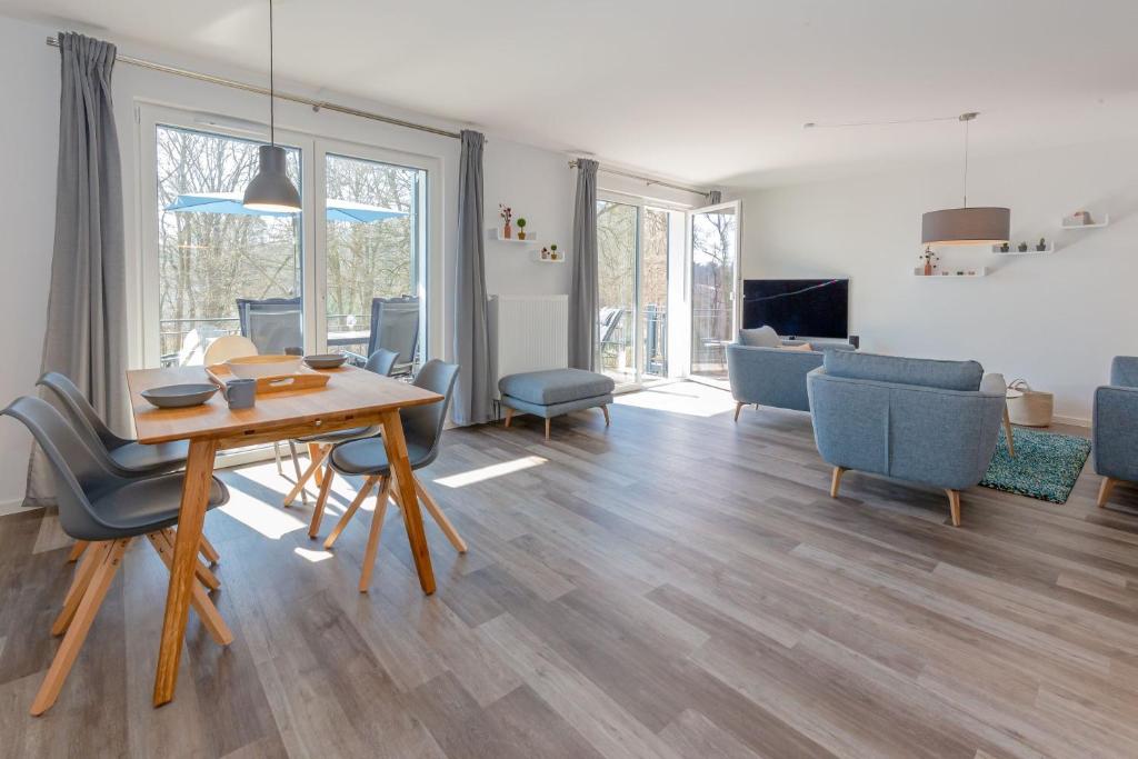 a living room with a wooden table and chairs at Haus Waldidyll, Vergissmeinnicht - Bade- & Saunawelt täglich inklusive in Ostseebad Sellin
