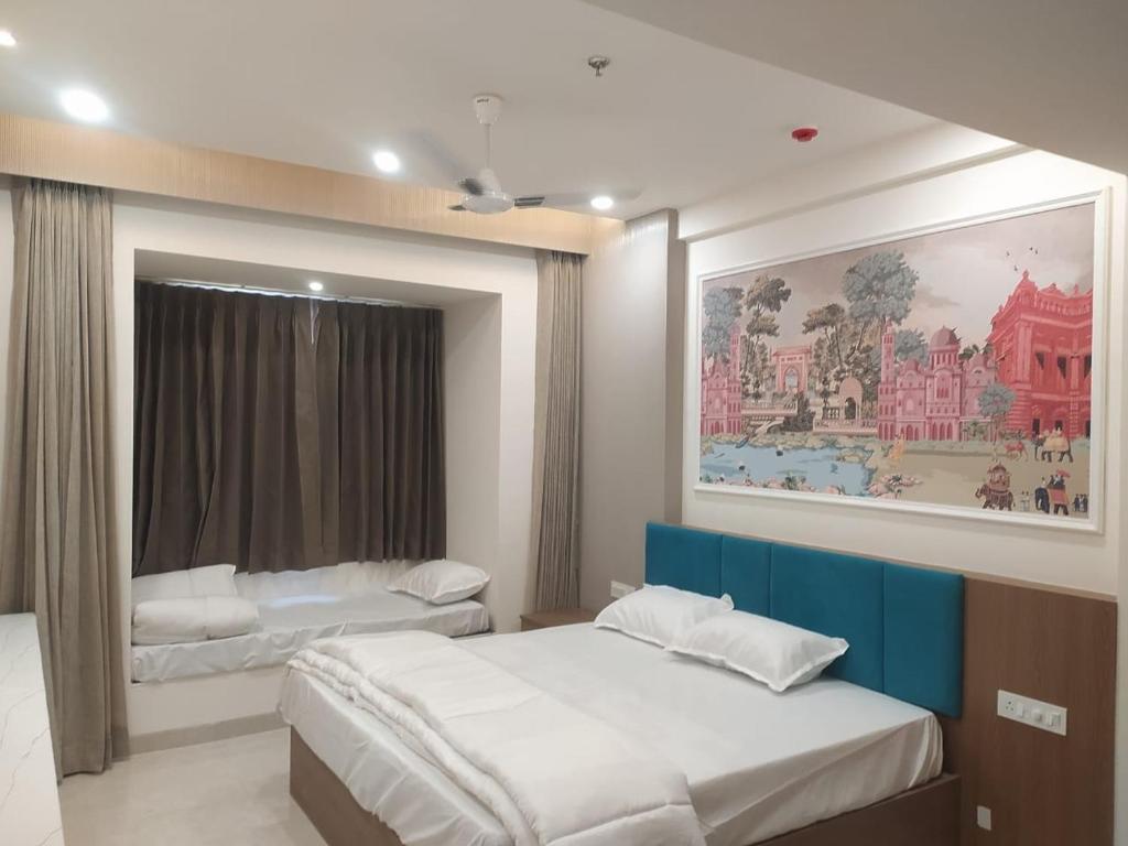a bedroom with two beds and a painting on the wall at The bhandhavghad regency in Udaipur