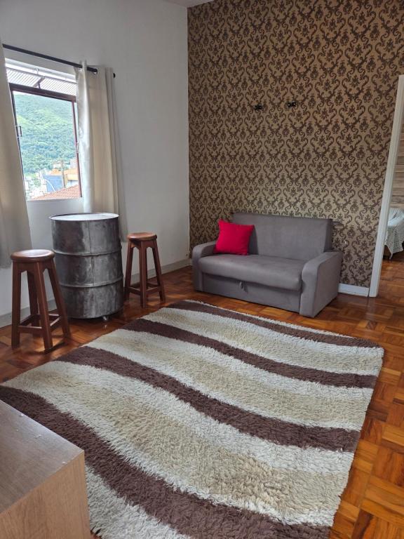 a living room with a couch and a rug at Casa confortável e central in Poços de Caldas