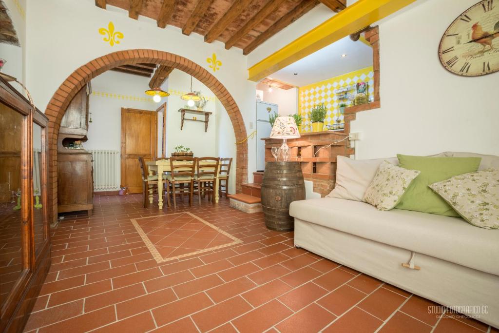 een woonkamer met een bank en een klok aan de muur bij Tognazzi Casa Vacanze - Casa Il Giglio in Certaldo