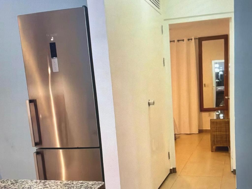 a stainless steel refrigerator in a kitchen with a hallway at Palm Oasis Bonaire in Kralendijk
