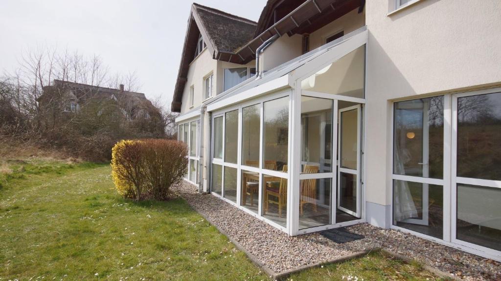 an extension of a house with sliding glass doors at Strandhaus Lobbe, App 04 - Bade- & Saunawelt täglich inklusive in Lobbe