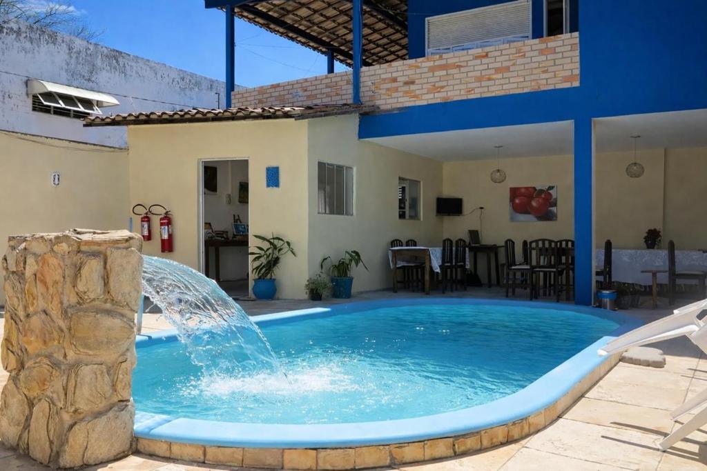 a pool with a water fountain in a yard at Pipa Hotel Pe na Areia in Pipa