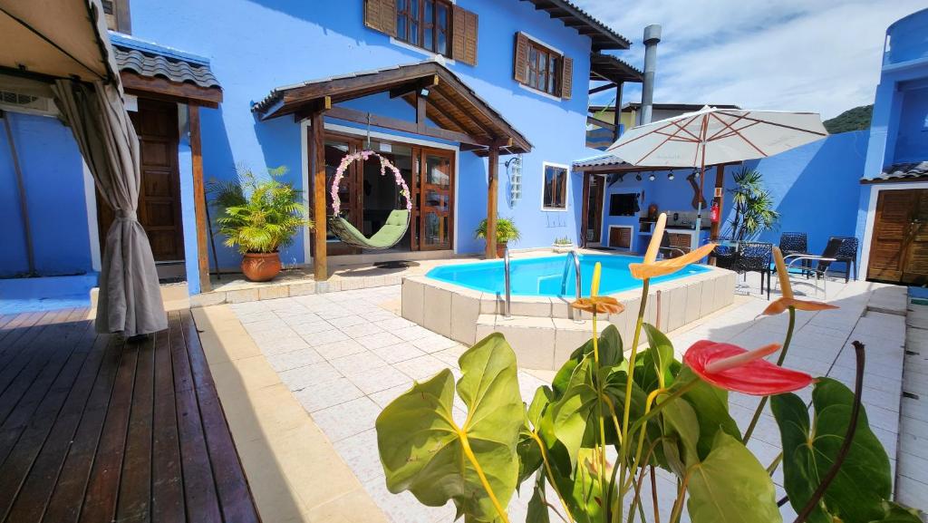 a patio with a pool and a house at Recanto da Dona Luiza - Pousada in Florianópolis