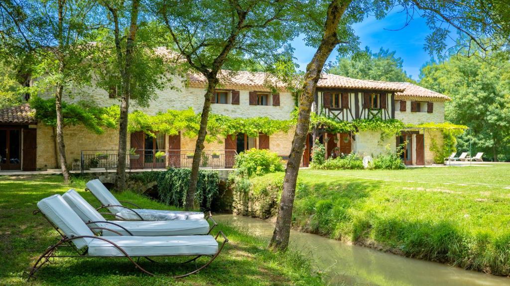 a pair of lounge chairs in front of a house at Gîte le Moulin Samsara in Homps