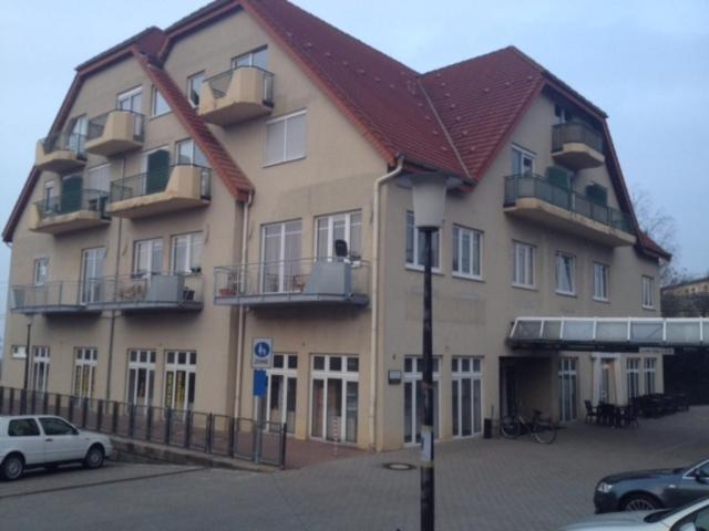 ein großes Gebäude mit davor geparkten Autos in der Unterkunft Ferienwohnung Gittersee in Dresden