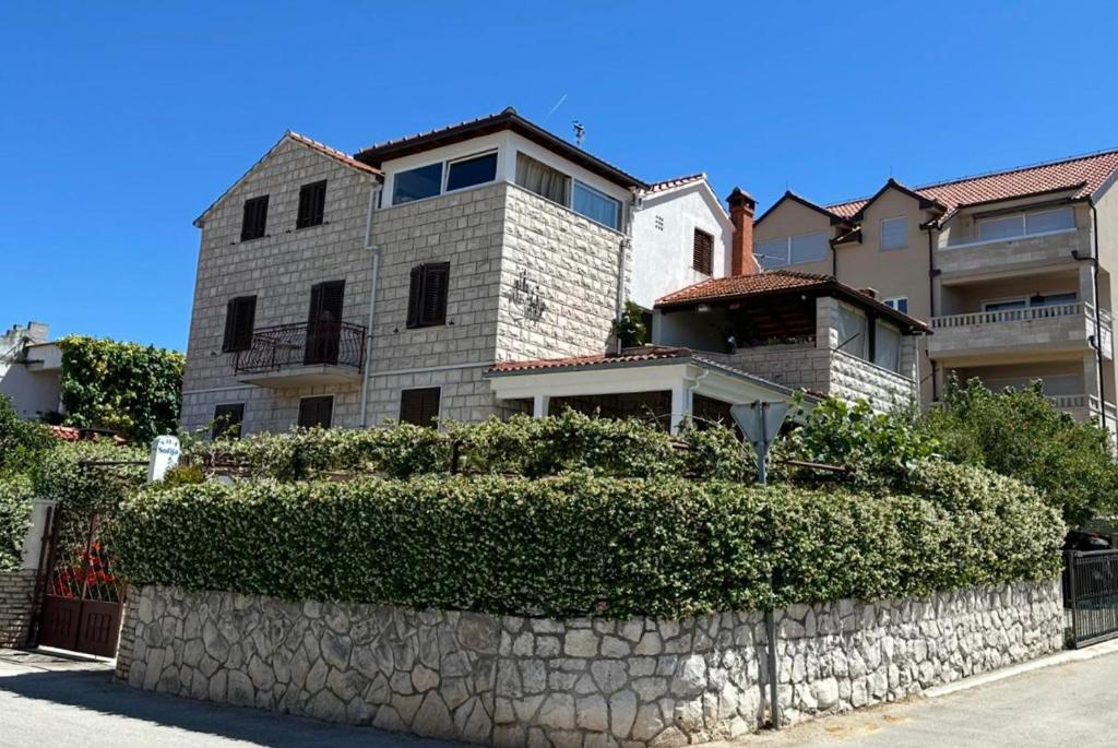 a large house with a stone wall in front of it at Villa Sofija in Supetar