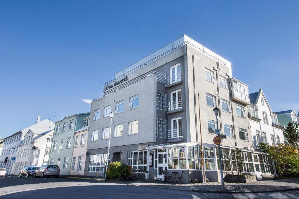 ein großes graues Gebäude an einer Stadtstraße in der Unterkunft Hotel Ódinsvé in Reykjavík