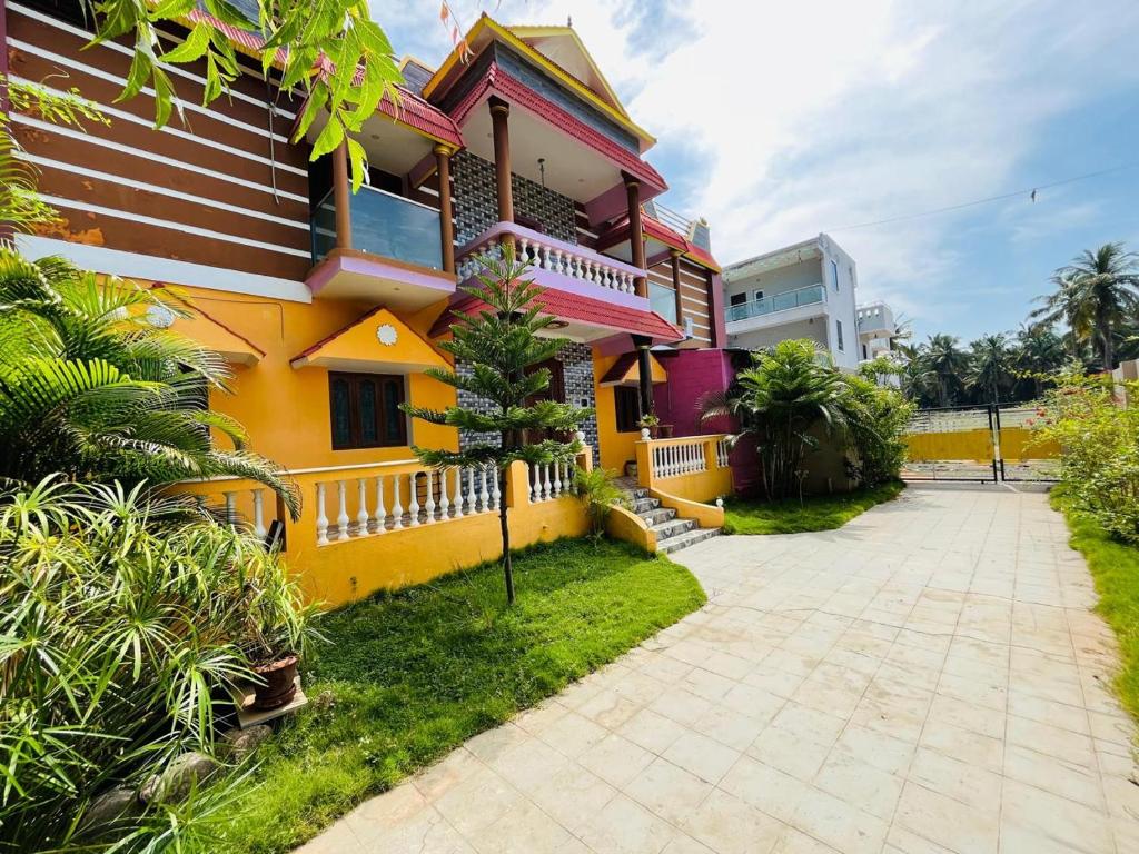 a colorful house with a pathway in front of it at selvis casa in Pondicherry