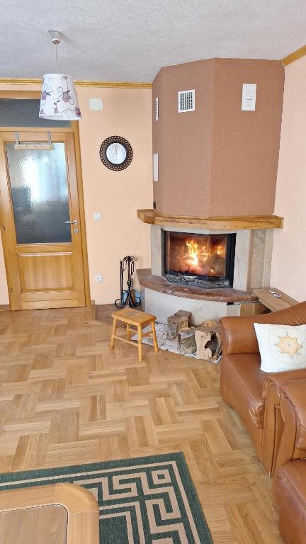 a living room with a couch and a fireplace at Kuća za odmor Diva Blidinje, Risovac 455 in Blidinje