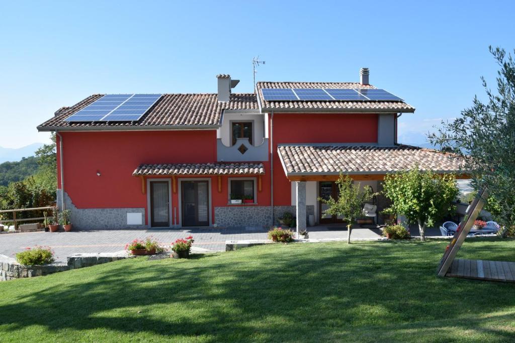 a red house with solar panels on the roof at Agriturismo Terra Verde in Rotonda