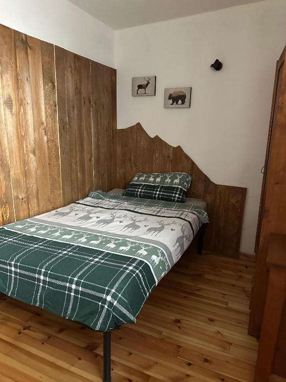 a bed in a room with a wooden wall at Il nido delle cime in Capriana