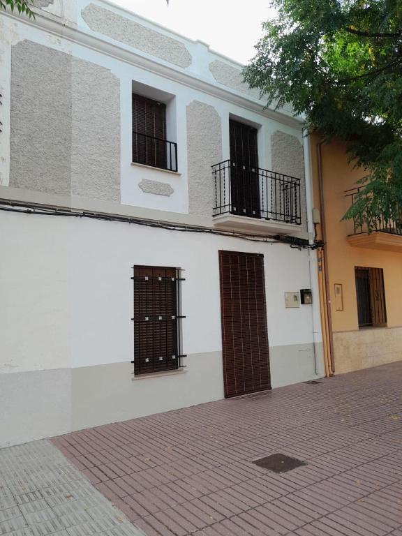 a white building with two doors and windows at Ca l'Agüela -Fontanars dels Alforins in Fontanares