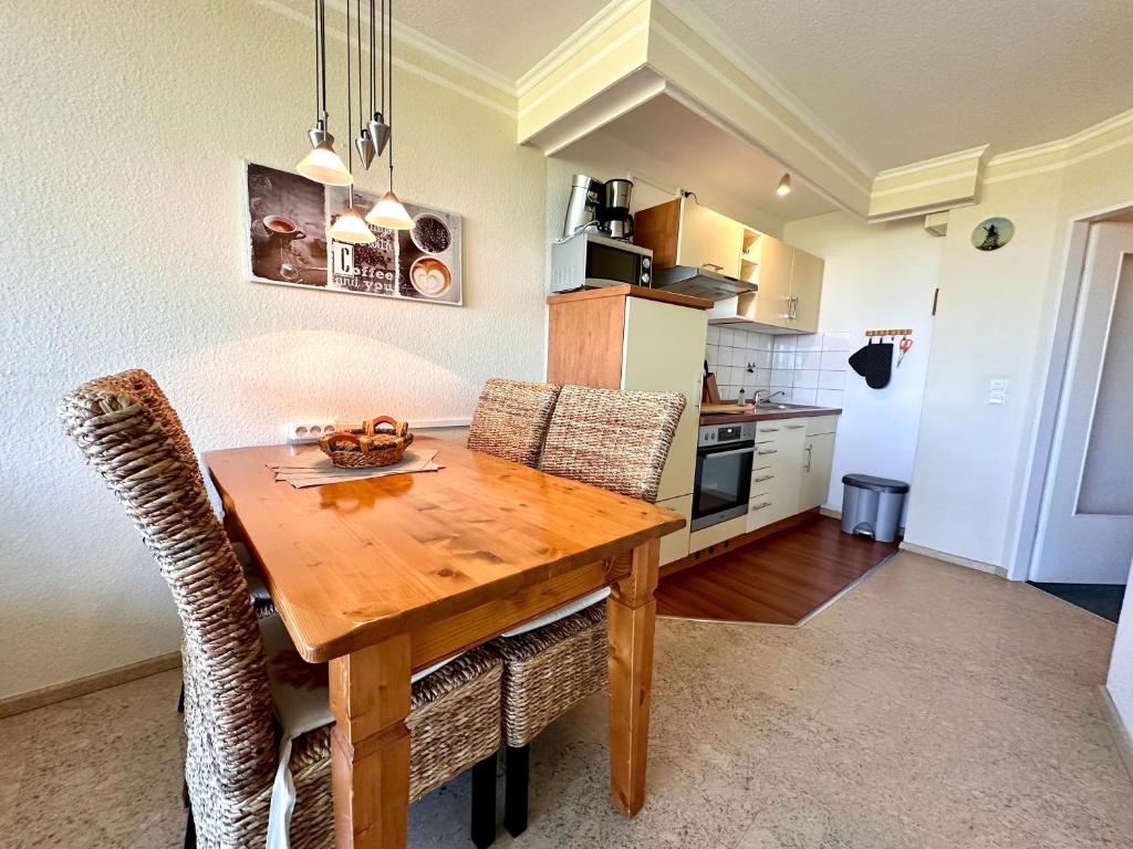 a kitchen with a wooden dining table and chairs at Ferienwohnung De Keef in Dorum-Neufeld