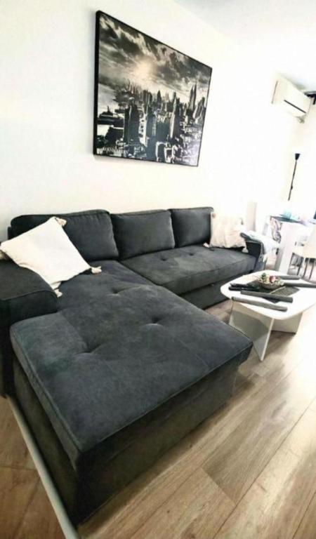 a living room with a couch and a table at Juls 2 bed flat- Bulgaria mall FREE parking in Sofia