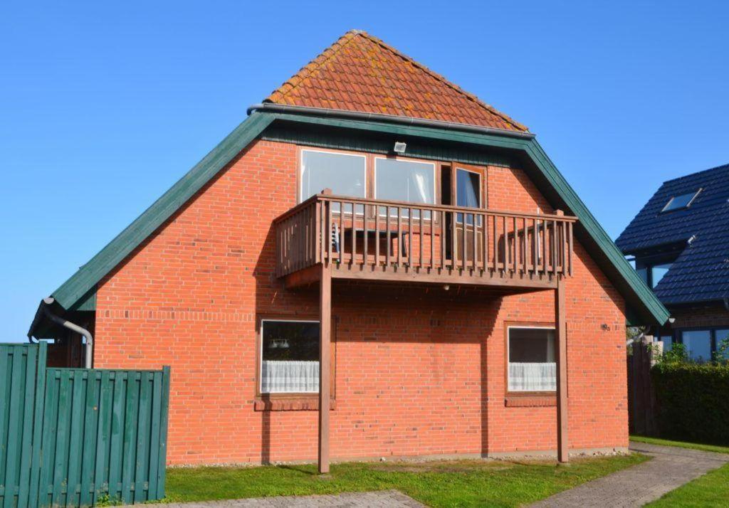 a red brick building with a balcony on it at LHMW19A12-FeWo-Seglerfruend-II in Westerbergen