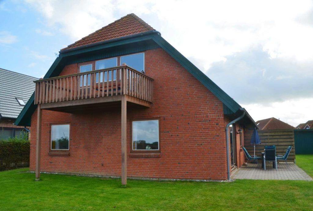 a brick house with a balcony on top of it at LHMW19A14-FeWo-Seglerfruend-IV in Lemkenhafen auf Fehmarn