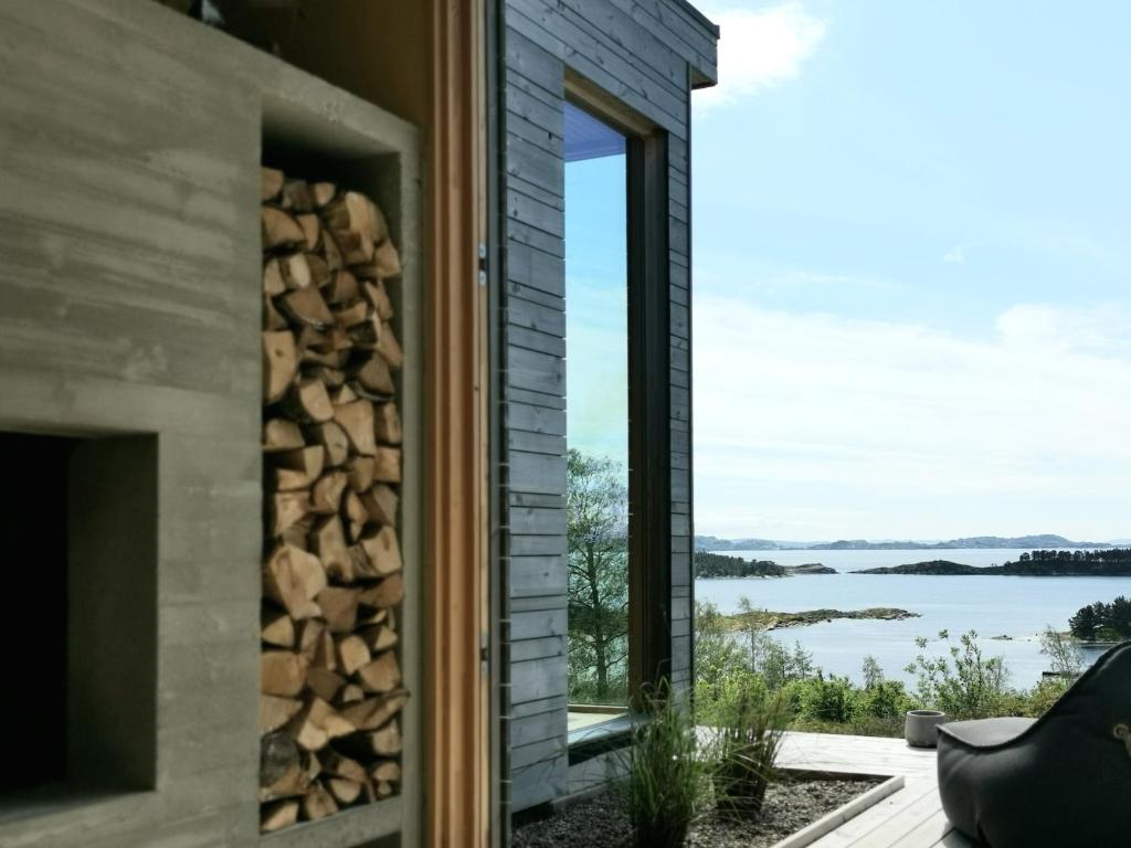 a house with a fireplace and a view of the water at FjordView Sanctuary in Nedstrand