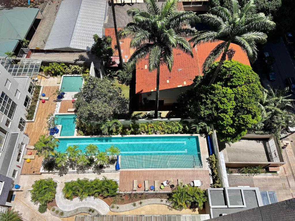 an overhead view of a swimming pool with palm trees at The Expression Building - Setor Bueno - THP in Goiânia