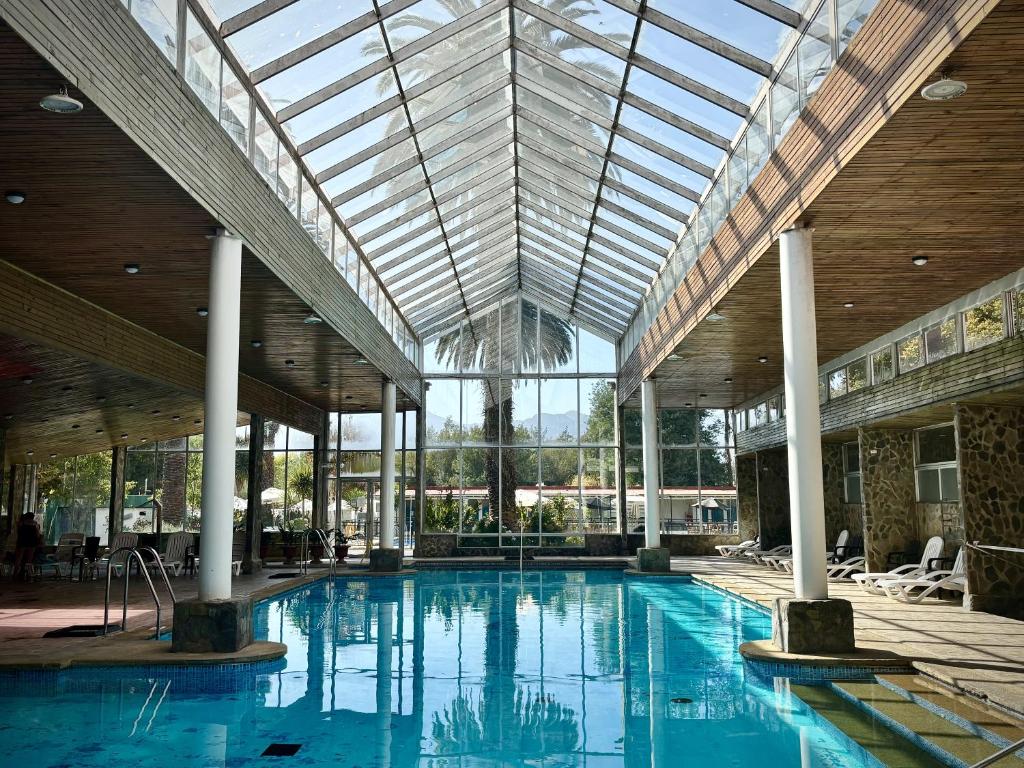 a large swimming pool in a building with a glass ceiling at Resort Termas de Panimávida - Hotel & Spa in Panimávida