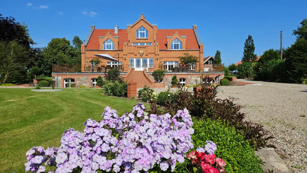 a large house with flowers in front of it at Herrenhaus Darbein in Dargun