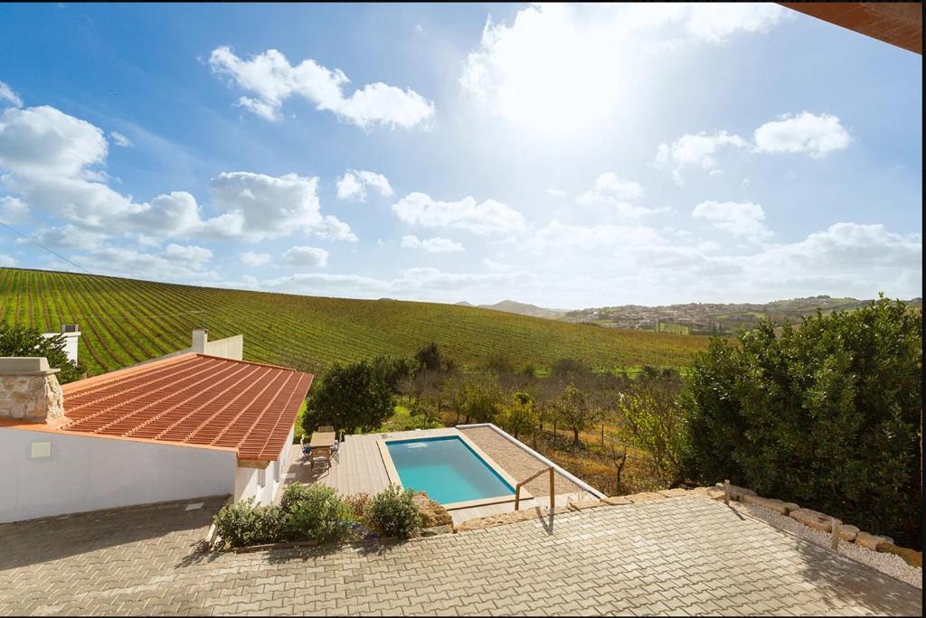 a villa with a swimming pool and a vineyard at Coastal Vineyard Hideaway in Torres Vedras