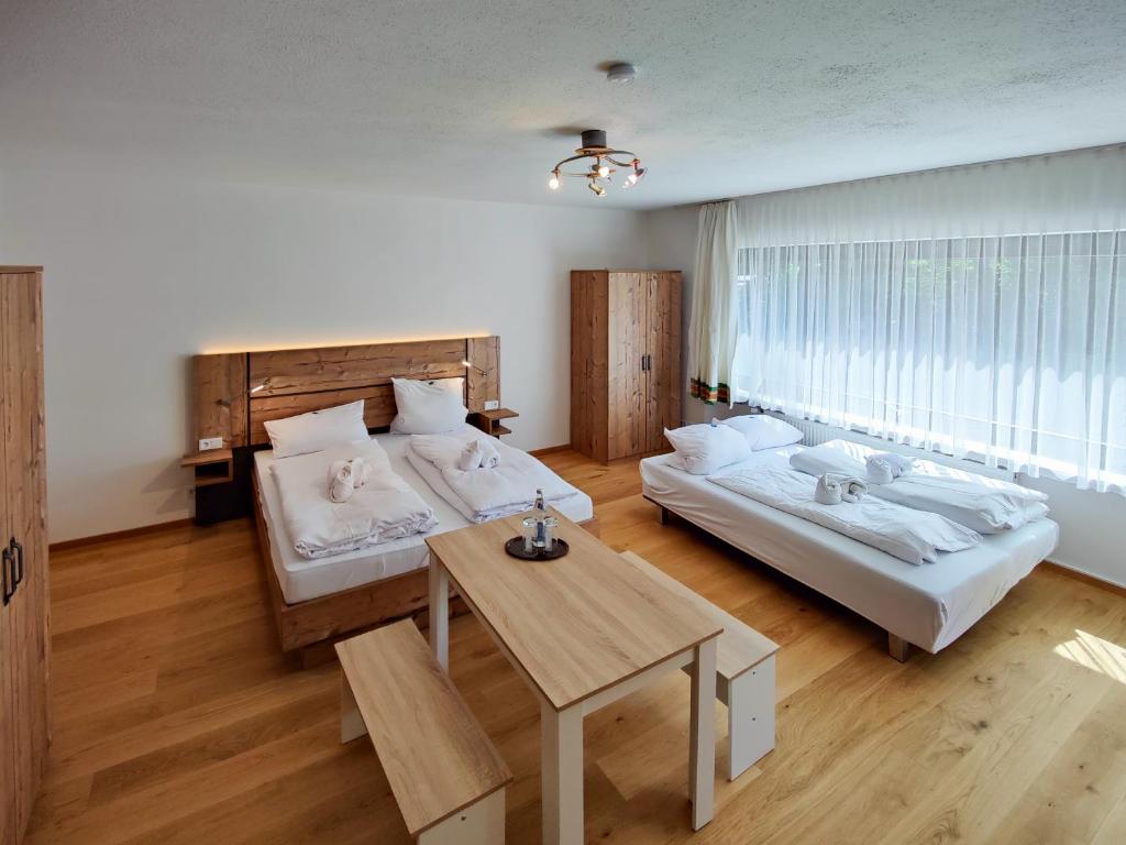a bedroom with two beds and a table in it at Bayerischer Wald, FVI Hotel und Restaurant in Neukirchen