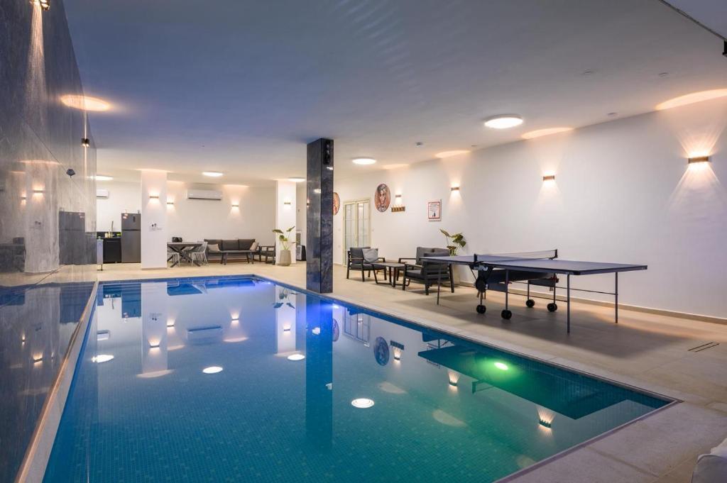 a pool with a ping pong table in a house at Villa Alba in Majdal Shams