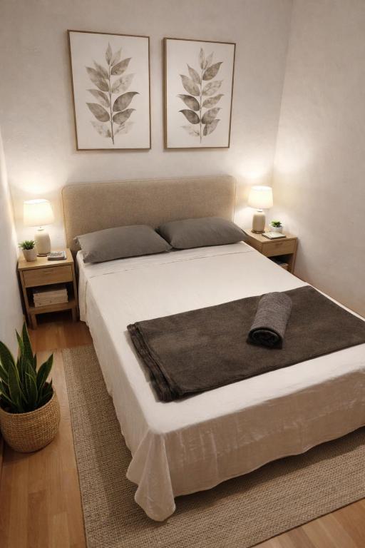 sypialnia z dużym białym łóżkiem i dwiema lampami w obiekcie Affordable apartament & rooms in city center w Barcelonie