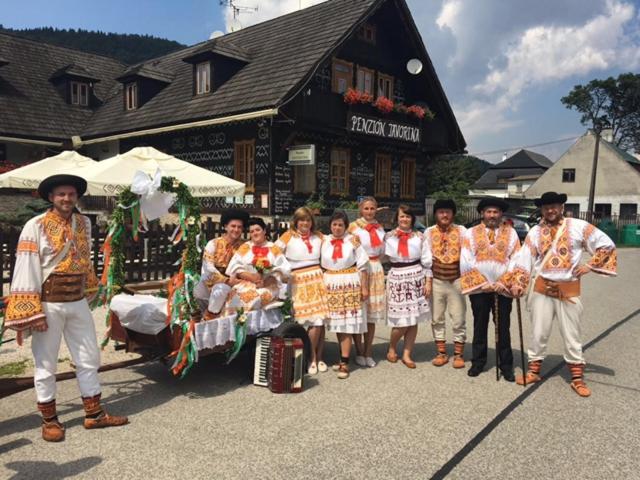 a group of people posing for a picture in front of a building at Penzion Javorina in Čičmany