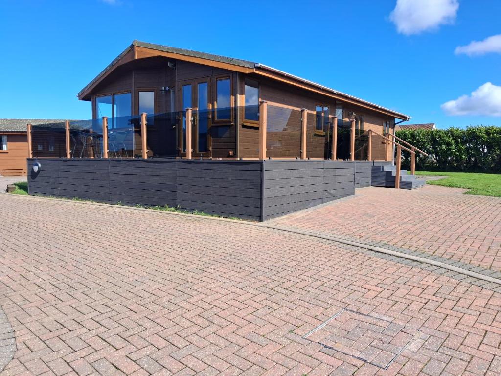 a house on a brick road in front of a building at ocean view 15 in West Down