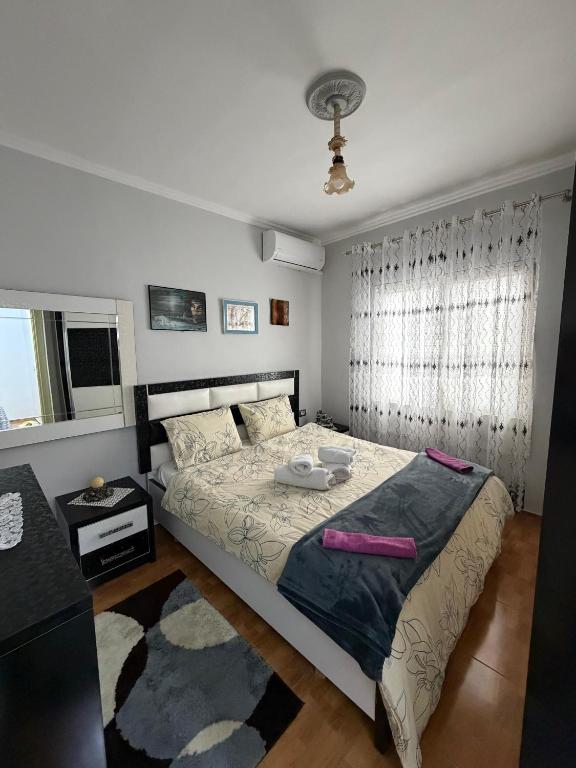 a bedroom with a large bed and a window at Guest house Luli Mucaj in Çorovodë