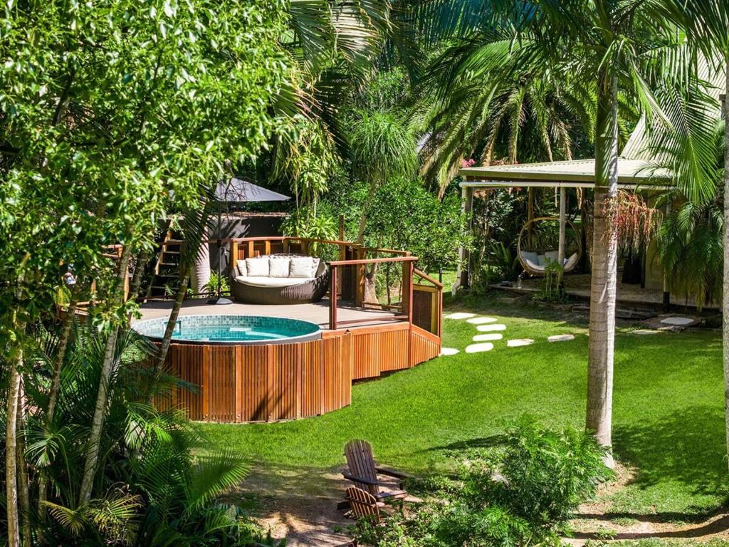 a backyard with a hot tub and a swing at Figtree Creek Retreat in The Pocket