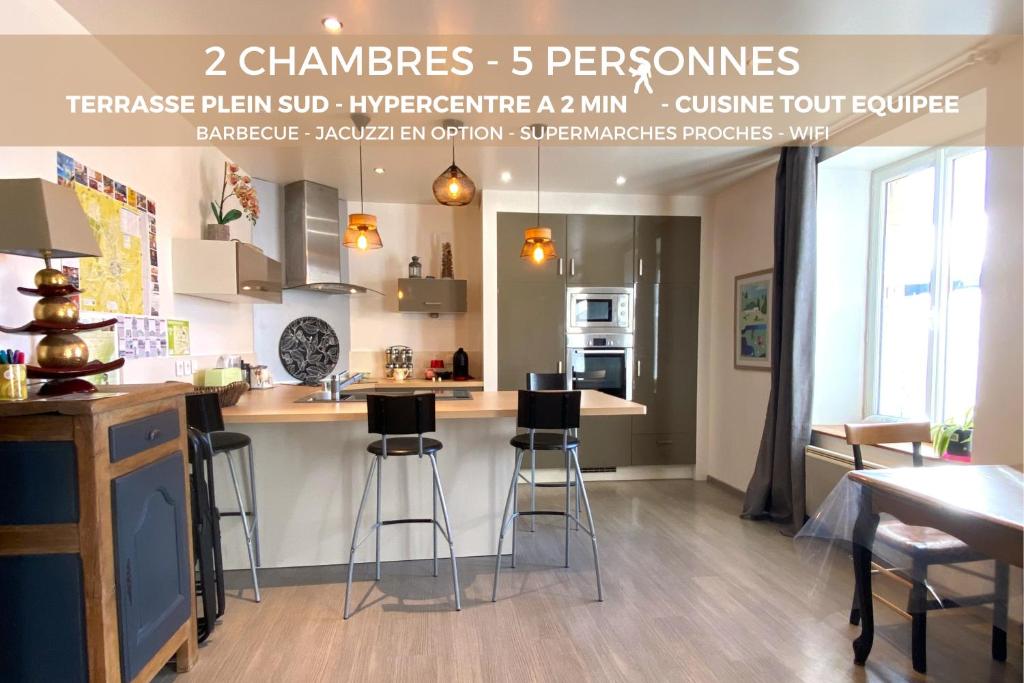a kitchen with a counter and bar with stools at Charisma - 2 chambres Proche hypercentre in Pontarlier