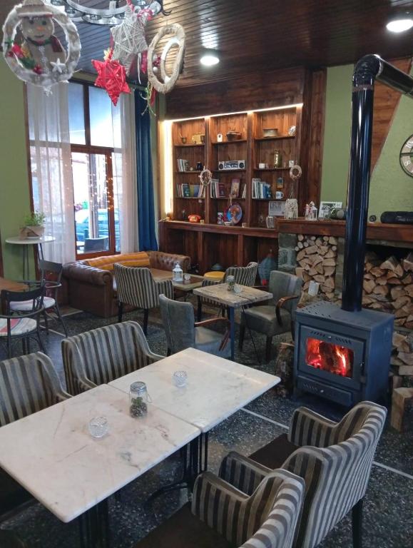 a restaurant with a fireplace and tables and chairs at FANTINO HOTEL in Domnista