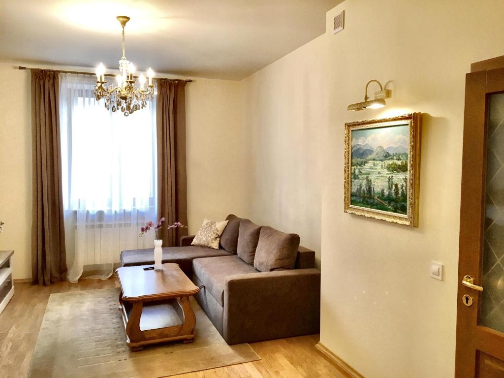 ein Wohnzimmer mit einem Sofa und einem Tisch in der Unterkunft Апартаменти у серці Львова in Lwiw