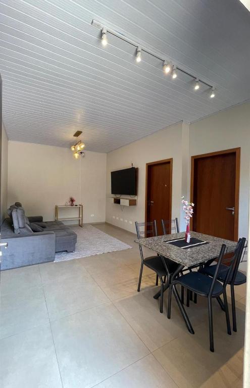 a living room with a table and chairs and a couch at suite privativa centro de Dourados in Dourados