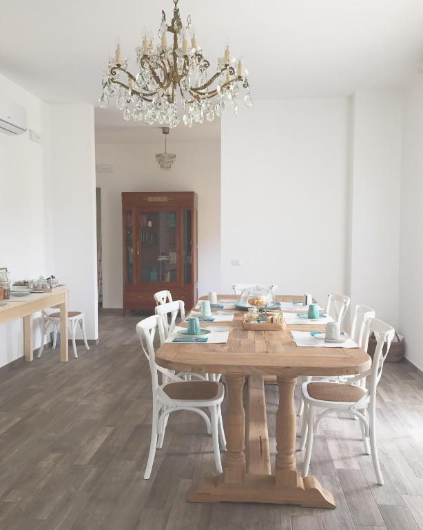 a dining room with a wooden table and white chairs at Il Gelsomino in Roseto degli Abruzzi
